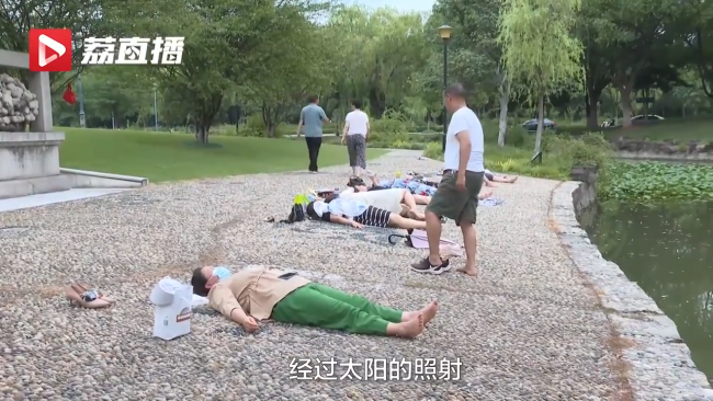公园鹅卵石地面躺满市民做热疗