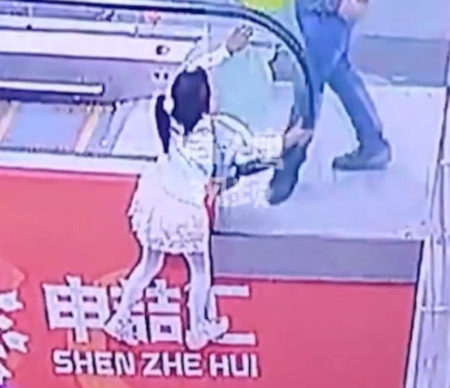 女童手扒扶梯双脚悬空被男子救起