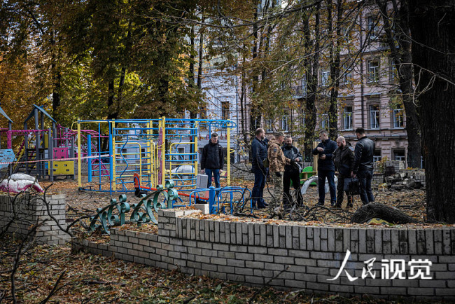 当地时间2022年10月10日，乌克兰基辅，紧急服务人员前往一个公园的儿童游乐设施旁边的爆炸现场。早上的爆炸发生在8点刚过，这是几个月来首都发生的最大规模的袭击。