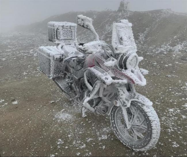 太冷了！小伙露宿山顶摩托车冻成“冰雕” 为拍美照值了！