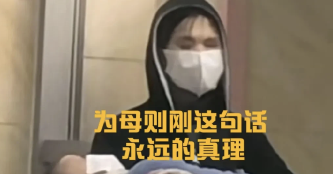 失明母亲用力抱着高烧宝宝排队就医