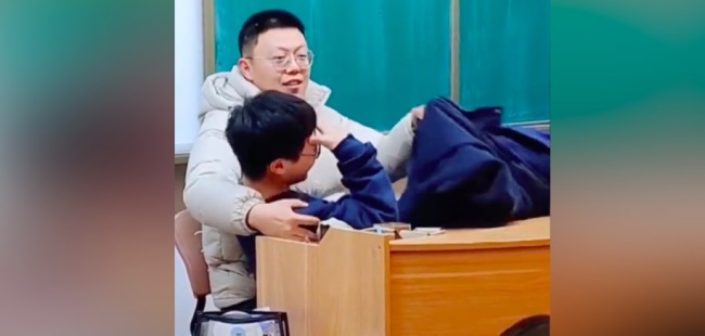 学生犯困老师搂其“哄睡”