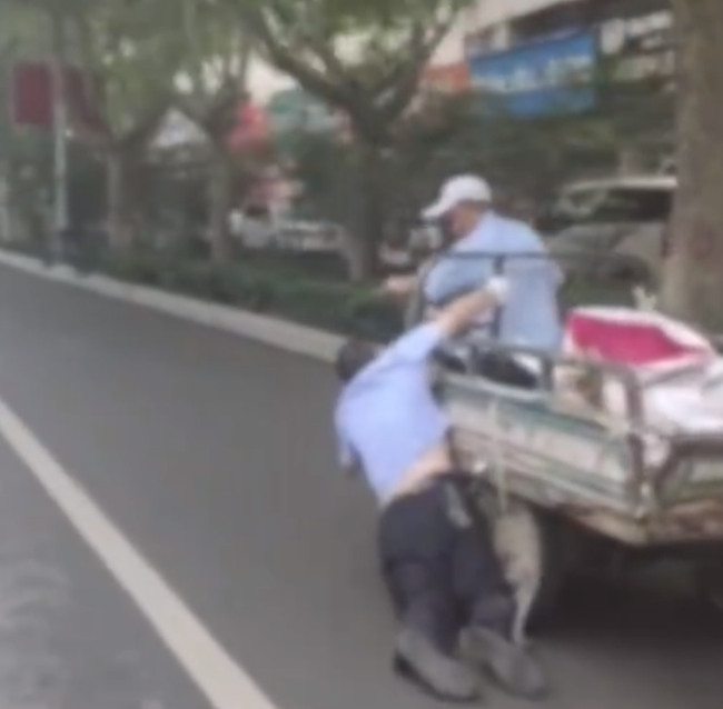 三轮车拖行交警百米 警方回应：系听力障碍者 对其行为予以谅解