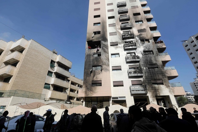 当地时间2024年2月21日，叙利亚大马士革Kafr Sousa地区，人们检查遭以色列空袭击中的建筑物损坏情况。（视觉中国）