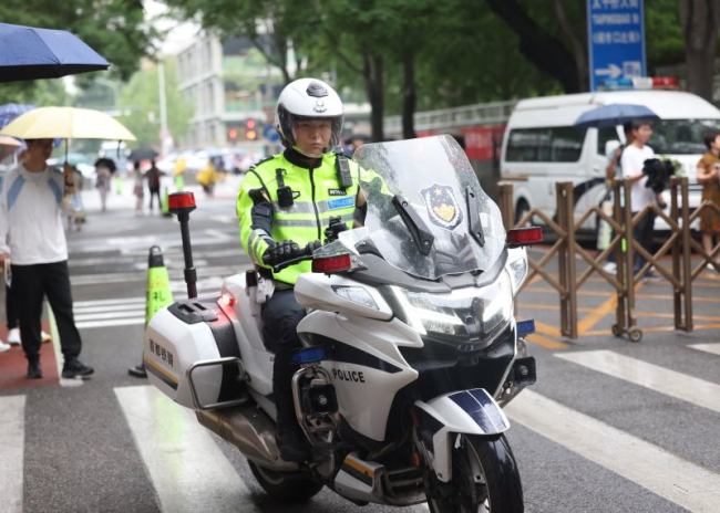 高考首日北京交警雨中值守，加强考点周边秩序疏导