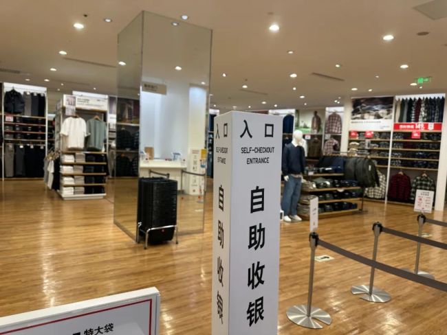 双11的优衣库线下店，店员和顾客都在忙着网购 ，但他们并不开心