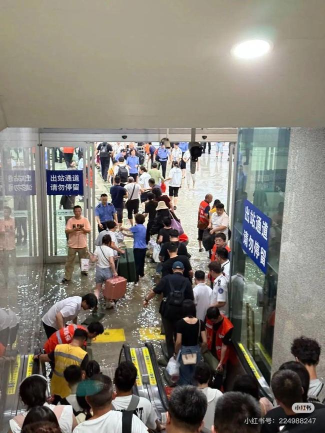成都东站旅客踩沙包出站 强降雨致积水严重