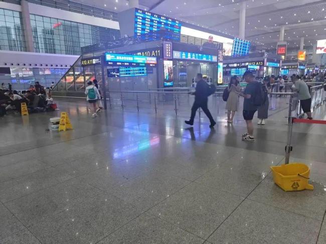 成都东站旅客踩沙包出站 强降雨致积水严重