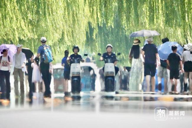 西湖景区游客上演“花式”避暑 高温下的游兴不减
