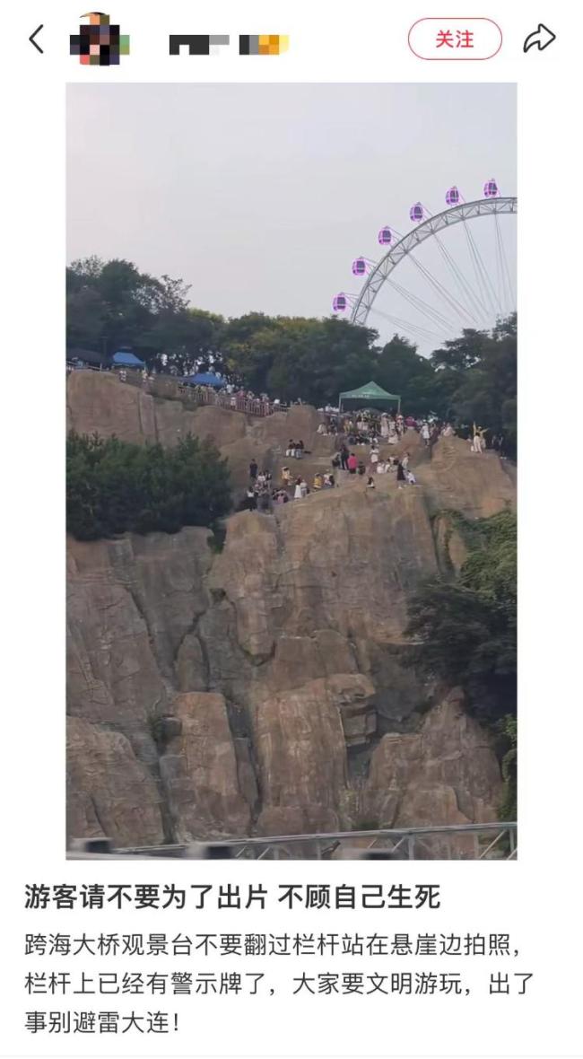 大连一观景台游客翻栏杆站悬崖拍照