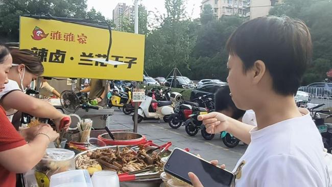 摊主女儿大口吃父母摊位剩食走红 人间烟火引共鸣
