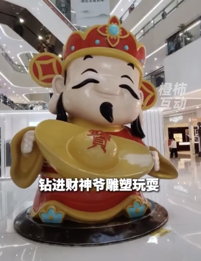 小孩哥"钻"进财神爷怀里出不来了