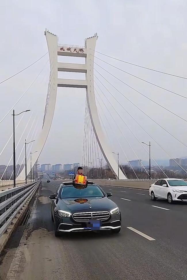 小孩哥从车辆天窗探出半身“炫”奖状