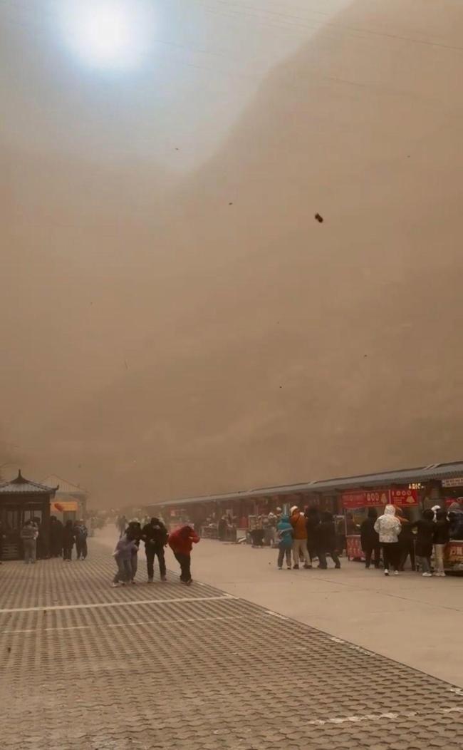 大同遭遇沙尘天气 游客直接被吹倒