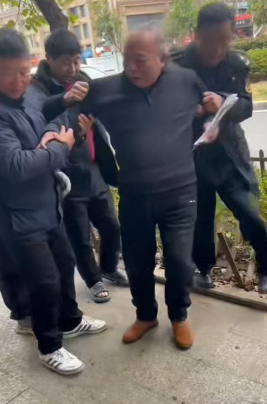 老人摔倒在街头花坛 众人接力扶起