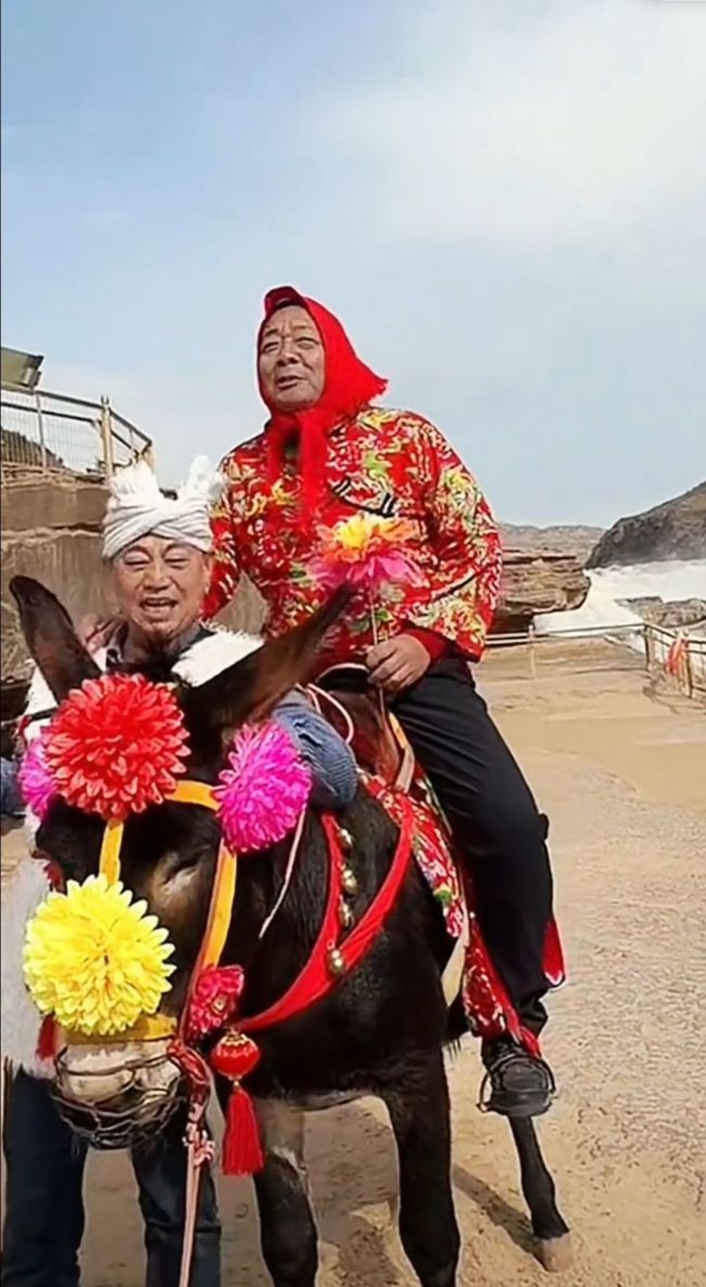 于东来戴红头巾穿花棉袄骑毛驴出游