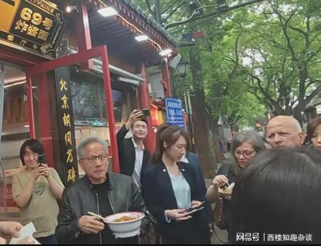 黄仁勋站店门口端着碗吃炸酱面 热爱生活的皮衣大佬