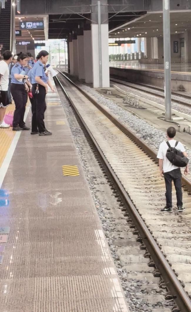 一男子突然跳下站台站上铁轨 经劝说安全“上岸”