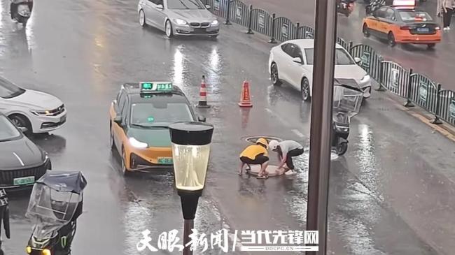 外卖小哥冒雨挪井盖 路人接力帮忙 善举温暖人心