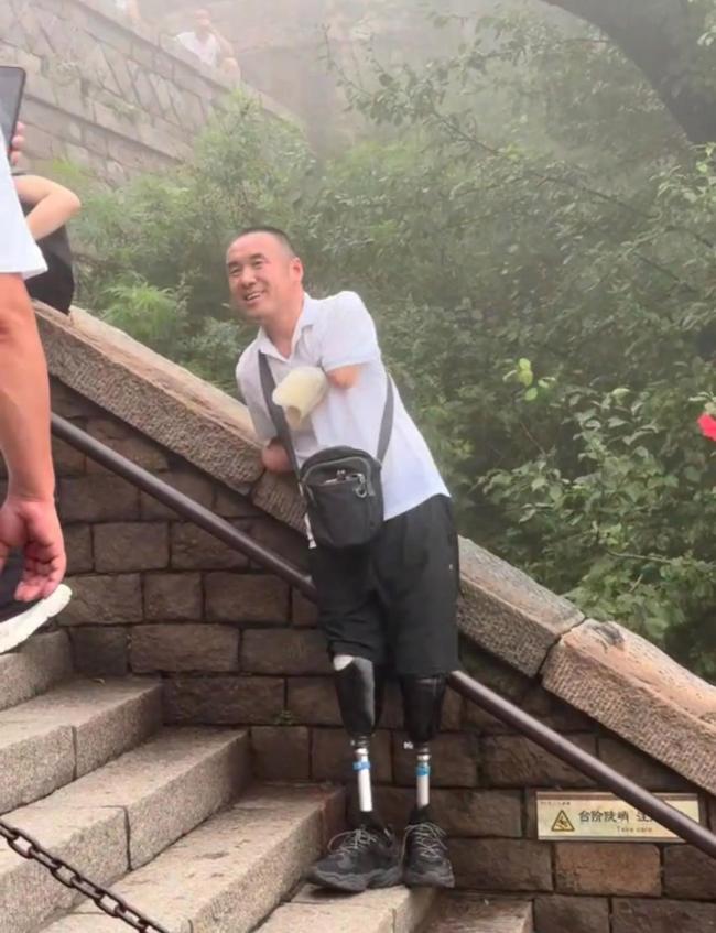 无手无脚男子5小时登顶泰山 毅力感动众人