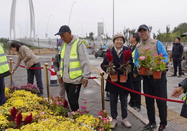 北京上百位市民雨中排队 接国庆鲜 花香传递节日温情
