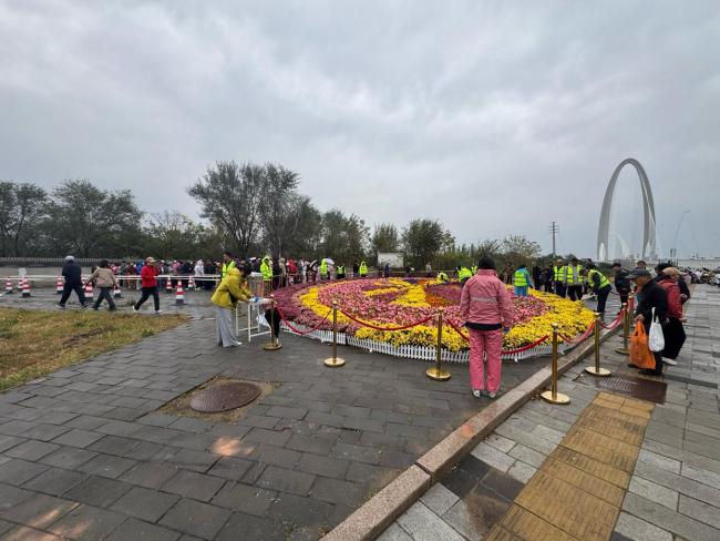 北京上百位市民雨中排队 接国庆鲜 花香传递节日温情