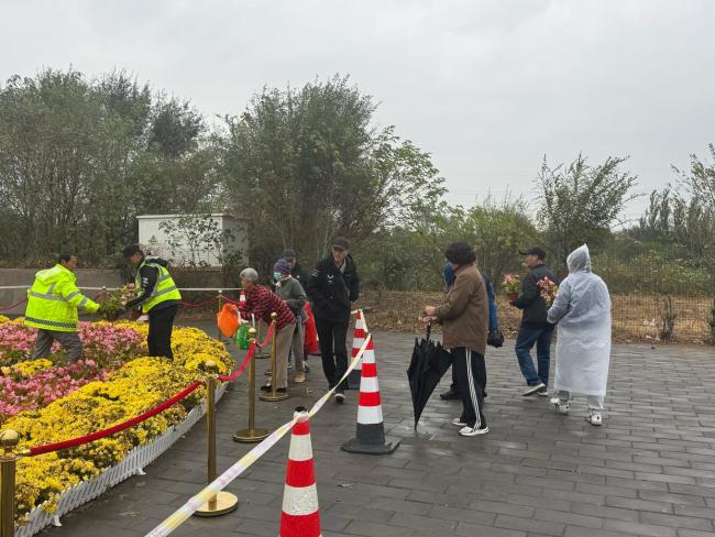 北京上百位市民雨中排队 接国庆鲜 花香传递节日温情