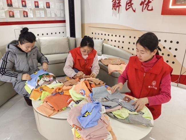 党员志愿者正在对捐赠的衣物进行清点和分装