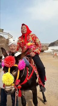 于东来戴红头巾穿花棉袄骑毛驴出游 分享平价经营理念